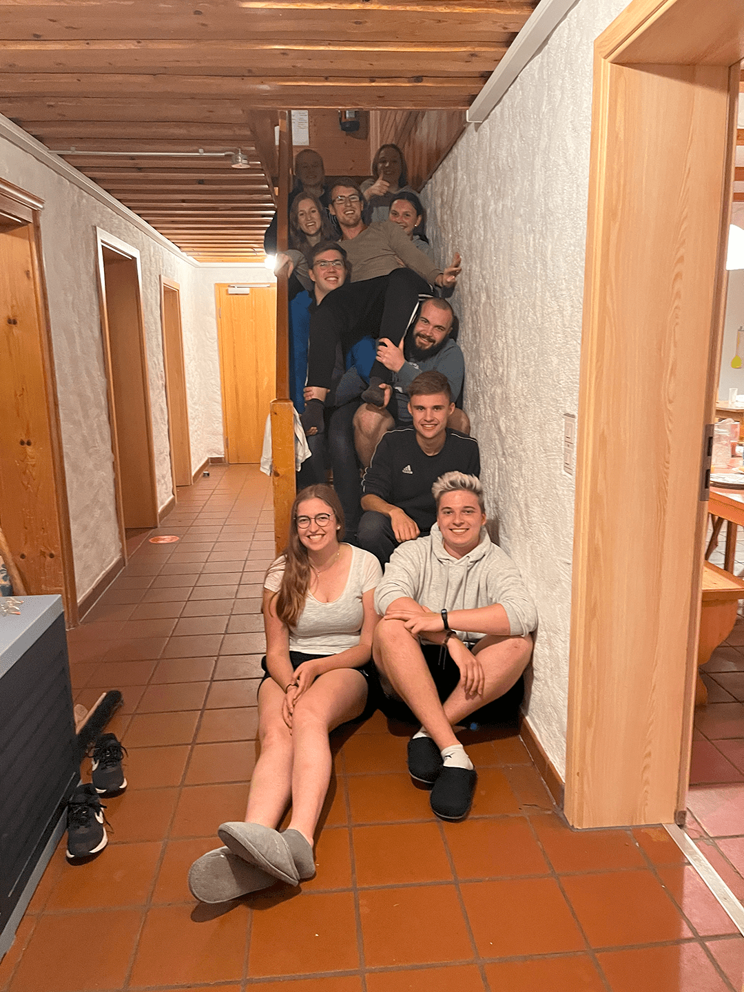Die Leiter der Minihütte 2022 auf einer Treppe sitzend
